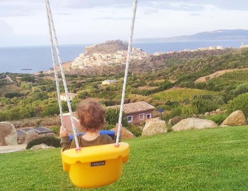 עומר מתנדנד מול טירה עתיקה. סרדיניה