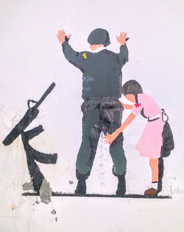 ילדה עוצרת חייל לבדיקה בטחונית גרפיטי ליד בית הקברות האורתודוקסי,…